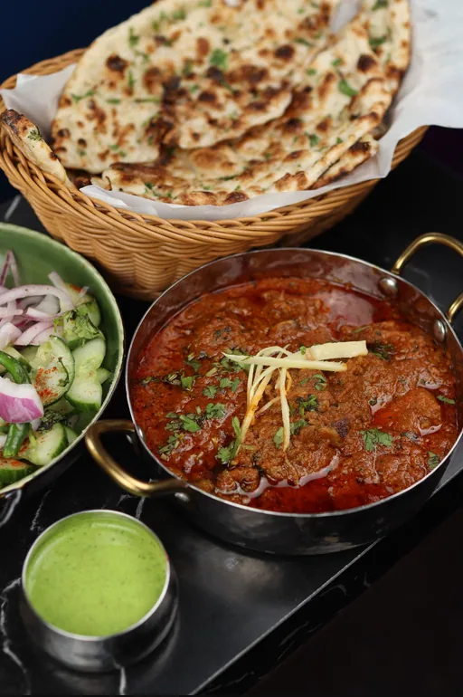 Bone-in mutton curry served with rice and bread